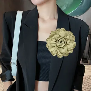 Detailansicht der großen Champagner-Satin-Rosenbrosche am Revers eines Blazers