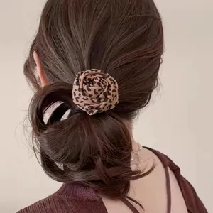 Retro leopard print rose hair scrunchie shown in a stylish low ponytail hairstyle
