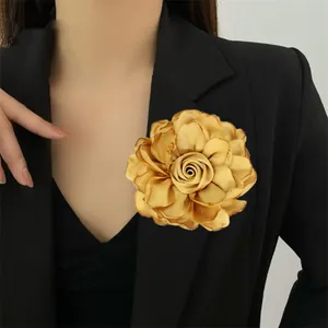 Makroaufnahme einer großen Champagner-Satin-Rosenbrosche an einem schwarzen Blazer