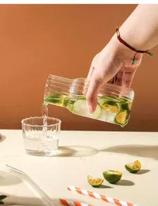 Vue rapprochée d'eau versée dans une carafe en verre strié avec texture à vagues