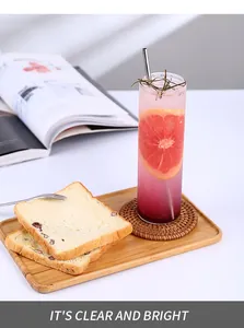 Grand verre avec paille en acier inoxydable et tranche de pamplemousse sur plateau