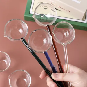 Set of four heat-resistant glass spoons with colorful long handles and pouring spouts