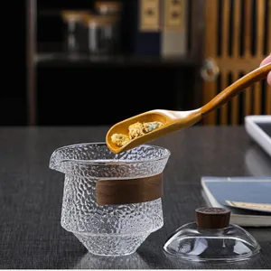 Detail of hammered glass tea pitcher with walnut wood handle and matching stirrer