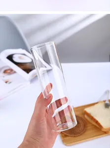 Gros plan d'une main tenant un grand verre highball transparent pour cocktails et jus