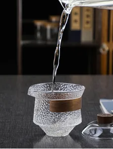 Detailed view of Japanese hammered glass tea pitcher with heat-resistant wooden handle grip