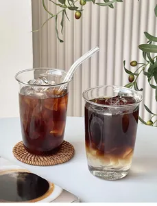 Détail macro de verres en borosilicate avec paille et café glacé sur dessous de verre tissé