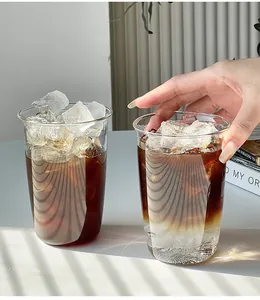 Détail macro de deux tasses en verre borosilicaté minimalistes avec café glacé et glaçons