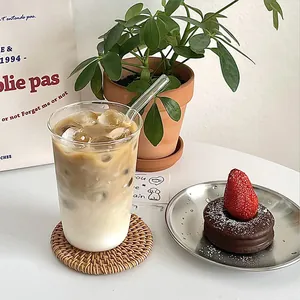 Tasse à café minimaliste en verre borosilicate avec paille sur dessous de verre tissé