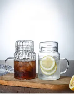 Close-up of heat-resistant glass tea cup with ribbed lid and handle on a wooden tray