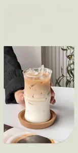 Close-up of bamboo-shaped borosilicate glass cup with iced coffee and cork coaster
