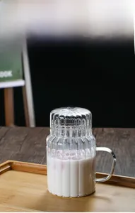 Detailed view of heat-resistant glass cup with vertical stripes, lid and handle