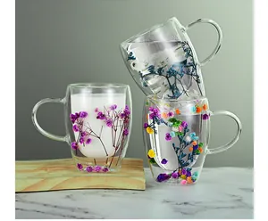 Macro detail of double-walled glass mugs with colorful dried flowers embedded inside