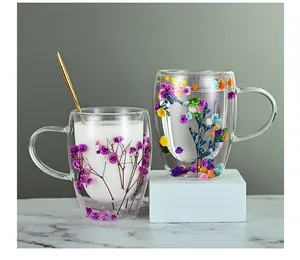 Detailed close-up of double-walled glass mugs with real dried flowers and a golden spoon