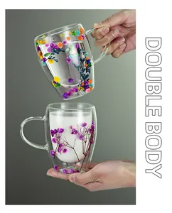 Detail of double-walled glass cup featuring colorful dried flowers and a transparent handle