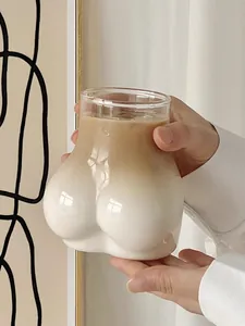 Detailed view of butt-shaped glass filled with layered iced coffee in a cozy home setting