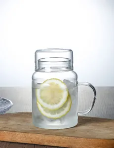 Detail of a heat-resistant striped glass mug with an ergonomic handle and a functional lid