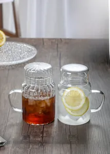 Close-up of heat-resistant striped glass tea cups with handles on a dark wood table