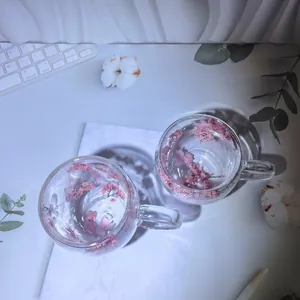 Aesthetic double-walled glass cup with pink dried flowers and handle for elegant tea time