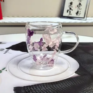 Close-up of double-walled glass cup with purple and pink dried hydrangea flower petals