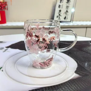 Detail of double-walled glass cup with pink dried flowers and clear handle