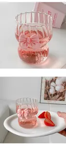 Detailed view of pink bow decoration on vertical ribbed borosilicate glass coffee cup