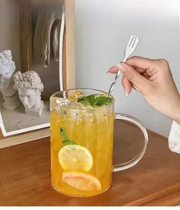 Close-up of a 1000ml glass mug with lemon juice, mint, and a metal stirring spoon