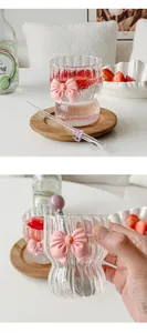 Close-up of pink bow glass coffee mug with vertical stripes and glass straw
