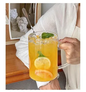 Detail of 1000ml glass mug with handle, cold fruit tea, ice cubes, and metal stirring spoon