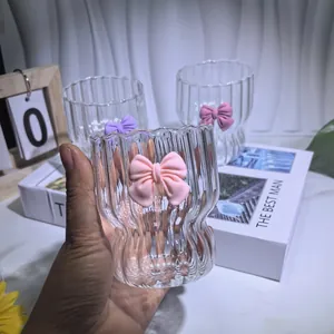 Detail of pink bow ornament on ribbed glass cup with elegant vertical wave pattern