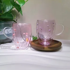 Detail of double-walled heat-resistant glasses with dried flowers and wood coaster