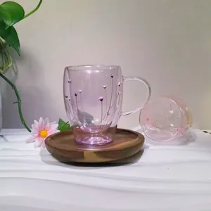 Detail of double-walled glass cup with dried flowers and solid wood coaster base