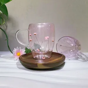 Insulated double wall glass mug with pink dried flowers and wooden coaster