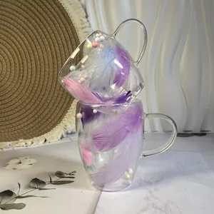 Close-up of double-walled glass mugs with colorful feathers and macaron balls inside