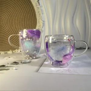 Double-walled glass coffee mugs with decorative feather and macaron ball filling