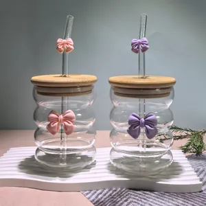 Close-up of wavy glass tumblers with bamboo lids and cute 3D bow ties details