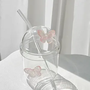 Dettaglio di una tazza in vetro con decorazioni farfalla rosa e coperchio a cupola