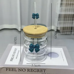 Detail view of wavy glass cup with blue bow tie design and bamboo lid showing dimensions