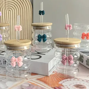 Detail of wavy textured glass cup with pink bow ornament and natural bamboo lid