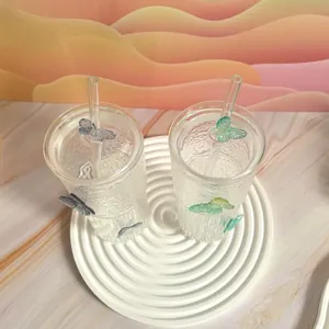 Detailed top view of textured glass cups with 3D butterfly accents and glass straws