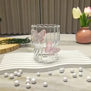 Detail of a fluted glass with 3D pink butterflies and scalloped rim on a stylish display