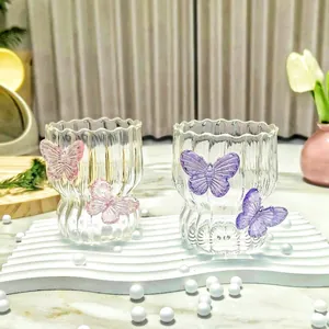 Detail of creative butterfly glass cups with vertical stripes and wavy rims for coffee