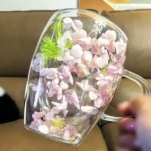 Close-up of double-walled glass mug with pink dried flowers and clear handle