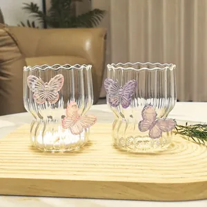 Creative glass water cup with 3D butterfly decor and vertical wave textures on wood base