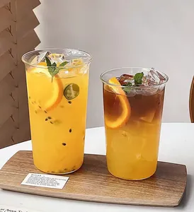 Detail of two heat-resistant glass cups with ice and fruit on a wooden tray