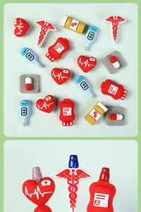 Macro detail of medical charms featuring heart EKG, Rx medicine bottle, and blood bag