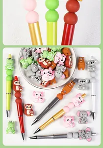 Detalle de bolígrafos DIY con cuentas de silicona de animales y cuerpos metálicos de colores