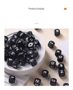 Macro-opname van zwarte vierkante siliconen kralen met witte letters voor DIY-sieraden