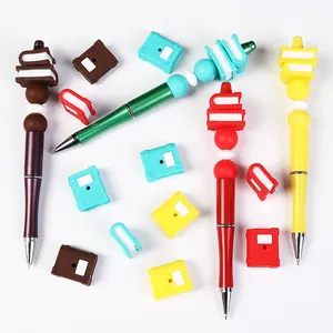 DIY beaded pen set with colorful silicone beads and 3D mini book charms on white background