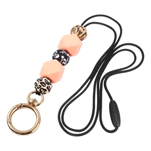 Detail of retractable silicone beaded lanyard with leopard and skull beads on gold clip
