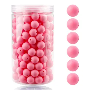 Detalle de cuentas redondas de silicona rosa en un tarro de plástico transparente